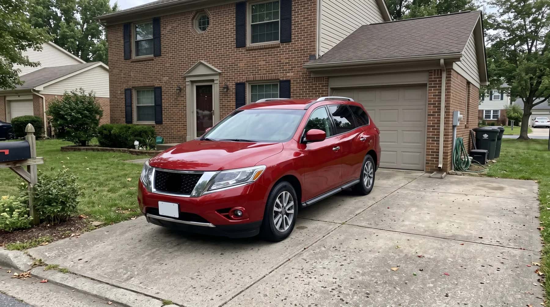 Red SUV in the driveway of a brick house