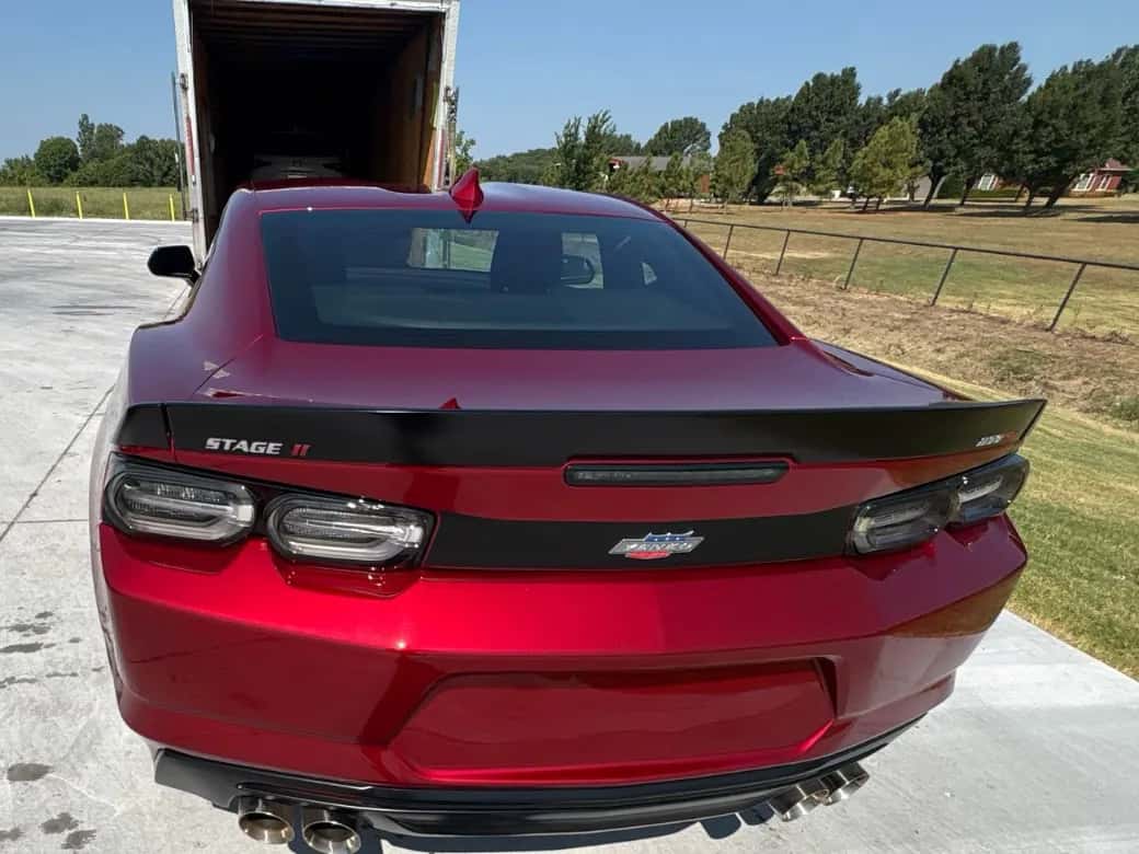 Red Chevrolet Camaro rolled out of an enclosed trailer